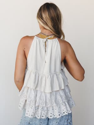 Shot from the back, this breezy tiered tank top shows off its eyelet ruffle hem and tie-back detail — the kind of top that looks just as good walking away as it does head-on.