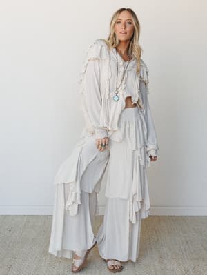 A head-to-toe cream and ivory look — ruffled crop top paired with wide-leg ruffle pants and a dramatic duster, layered with turquoise jewelry for that effortlessly romantic, free-spirited energy.