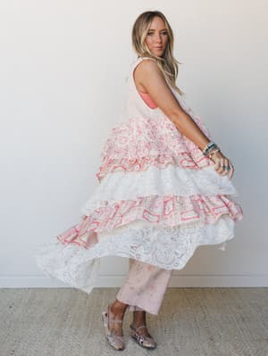 A model twirls in a dreamy tiered lace duster layered over floral wide-leg pants — the kind of outfit that feels like it was made for spinning in slow motion.