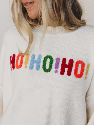 Close-up of a sweater with colorful 'HO! HO! HO!' text.
