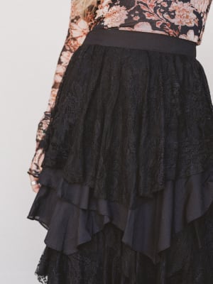 Black lace skirt with a floral top on a white background