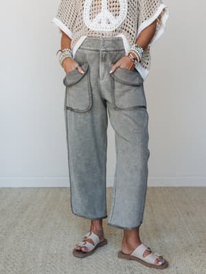 Acid-washed barrel-leg pants in faded olive styled with a crochet peace sign top and buckle sandals — the kind of outfit that looks effortless but was absolutely thought about.