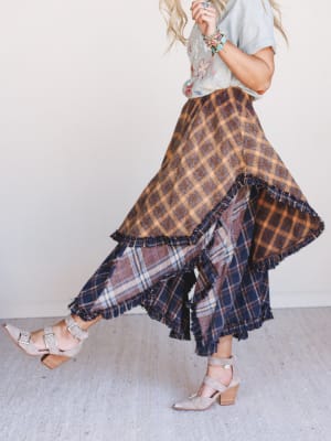 Woman wearing a plaid skirt with a neutral background