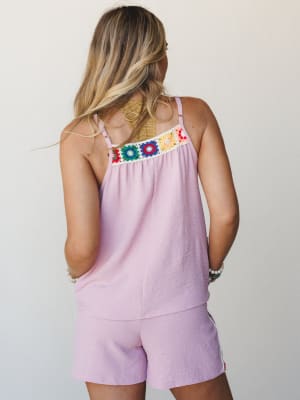 A back-facing model in a matching lavender pink crochet-trim cami and shorts set, the colorful granny square detail across the neckline doing all the talking in the most effortless summer way.