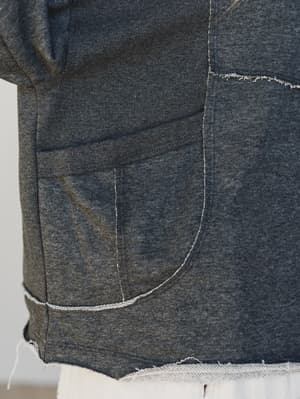 Close-up of a dark charcoal fabric with visible stitching on a plain background
