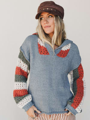 Woman wearing a colorful sweater with a neutral background