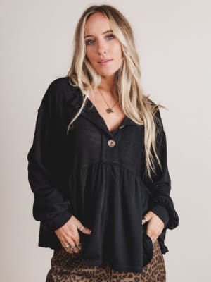 Woman wearing a black top with a plain background