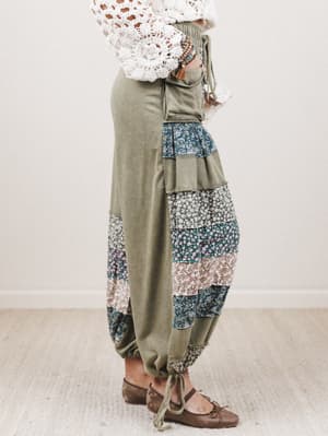 Person wearing a pair of patchwork pants with a plain background
