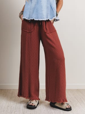 Woman wearing red patterned pants and a denim top