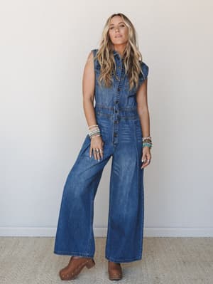 A wide-leg denim jumpsuit styled with stacked boho bracelets and studded clogs — the kind of outfit that feels effortless but clearly had some thought behind it.