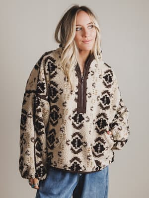 Woman wearing a patterned sweater with a neutral background