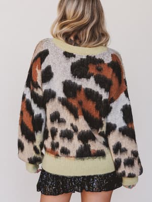 Person wearing a patterned sweater with a plain background