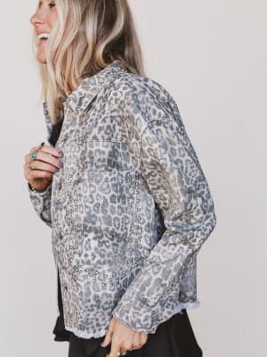 Woman wearing a patterned jacket against a plain background