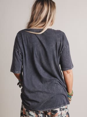 Person wearing a dark gray t-shirt with a neutral background