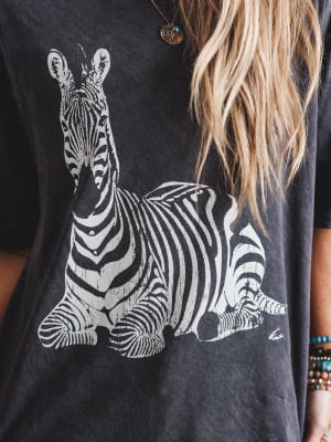 Person wearing a black t-shirt with a white zebra graphic
