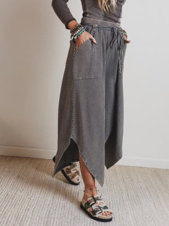 Person wearing a long, patterned pants with a neutral background
